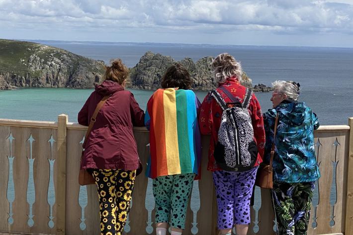 Four women looking at the view of the Minack and Porthcurno Bay