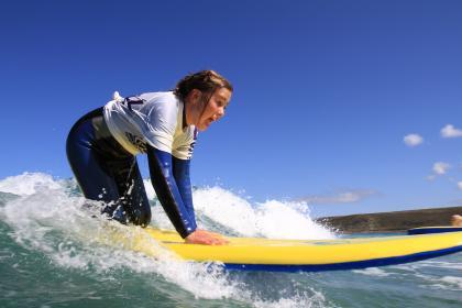 A girl surfing at Sennen Cove