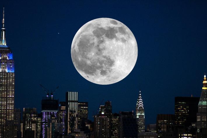 A full moon over the glittering towers of Manhattan